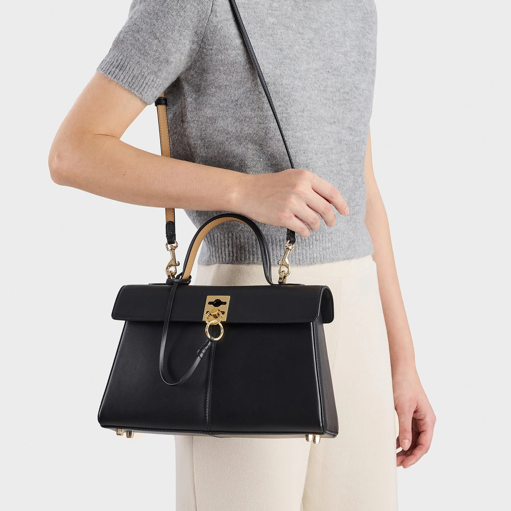 Sleek Solid Black Sharp Trapezoid Vintage Satchel With Distinctive Square Golden Clasp And Rear Full Length Zippered Compartment
