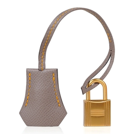 Vibrant Amber Orange Muted Ash Grey Contrast Compact Trapezoid Hand Tote With Polished Golden Twist Lock Hardware And Matching Suspended Metal Padlock Charm