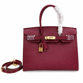 Rich Deep Burgundy Fine Grain Structured Trapezoid Hand Carry Tote With Glossy Luminous Golden Twist Lock Hardware And Matching Suspended Engraved Padlock Charm